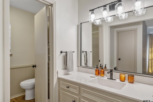 bathroom with wood-type flooring, toilet, and vanity