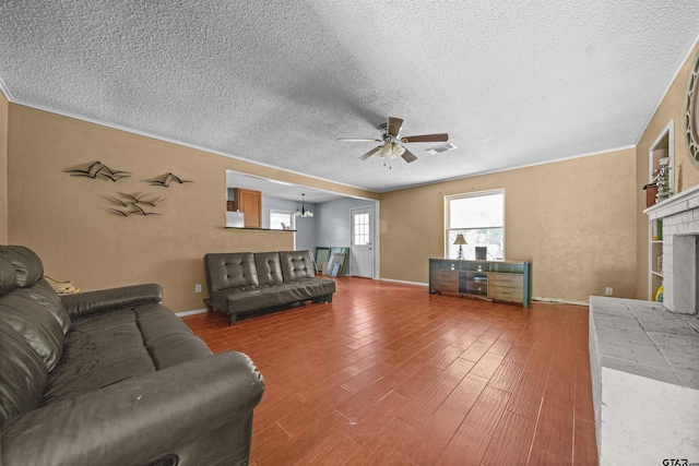 17607 Kristopher Cir, Whitehouse, TX 75791 - living room with ceiling fan, a textured ceiling, wood finished floors, and a brick fireplace