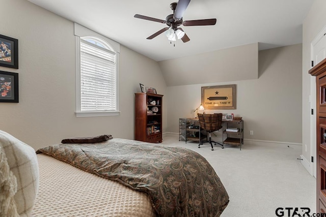 carpeted bedroom with baseboards, vaulted ceiling, and a ceiling fan