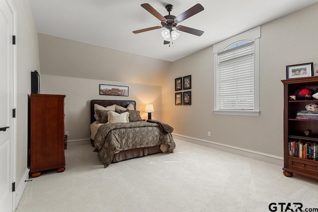 carpeted bedroom featuring lofted ceiling, ceiling fan, multiple windows, and baseboards