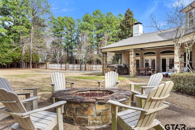 view of patio featuring a fire pit, french doors, and fence