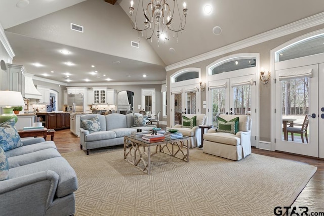 living room with arched walkways, french doors, visible vents, ornamental molding, and high vaulted ceiling