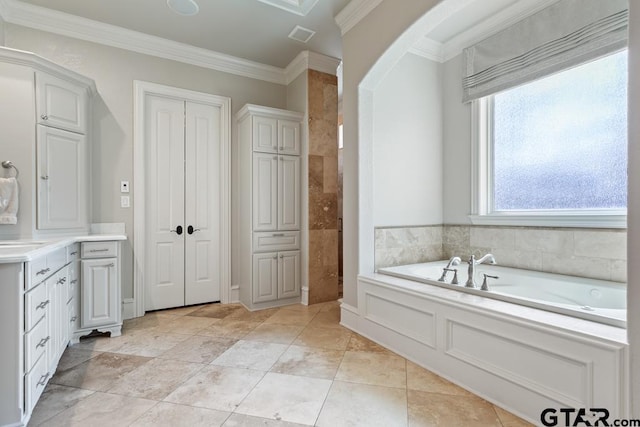 bathroom with a garden tub, tile patterned floors, ornamental molding, and vanity