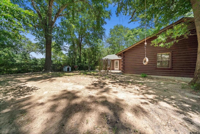 225 Springwood Cir, Chandler, TX 75758 - view of yard featuring a storage unit
