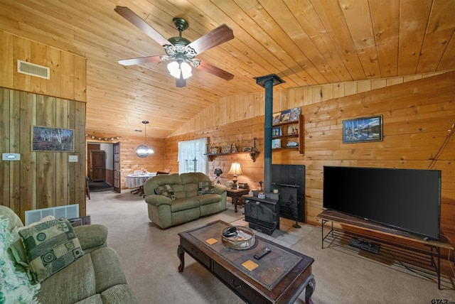 225 Springwood Cir, Chandler, TX 75758 - living area featuring a wood stove, wooden ceiling, wood walls, vaulted ceiling, and carpet