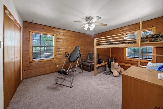 225 Springwood Cir, Chandler, TX 75758 - workout room featuring healthy amount of natural light, wooden walls, carpet floors, and ceiling fan