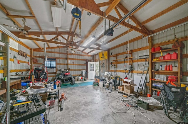 225 Springwood Cir, Chandler, TX 75758 - garage with a workshop area, metal wall, a garage door opener, and ceiling fan