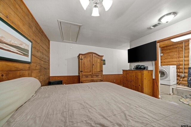 225 Springwood Cir, Chandler, TX 75758 - bedroom featuring attic access, wood walls, log walls, a wainscoted wall, and independent washer and dryer