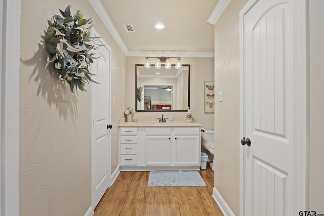 5298 Leaning Oaks Dr, Flint, TX 75762 - half bath featuring toilet, wood finished floors, ornamental molding, vanity, and baseboards