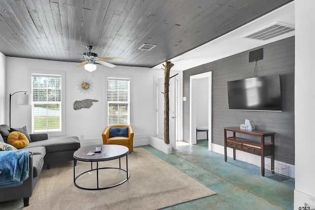 living room with concrete flooring, wood walls, ceiling fan, and wood ceiling