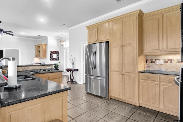 kitchen featuring tasteful backsplash, stainless steel appliances, dark stone counters, ornamental molding, and sink