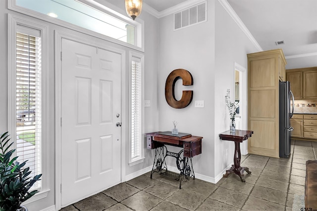 entrance foyer with ornamental molding and a wealth of natural light