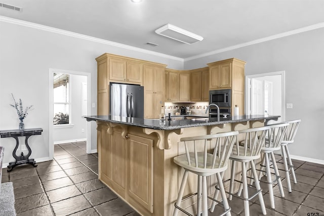 kitchen with a large island, a kitchen breakfast bar, stainless steel appliances, dark stone counters, and crown molding