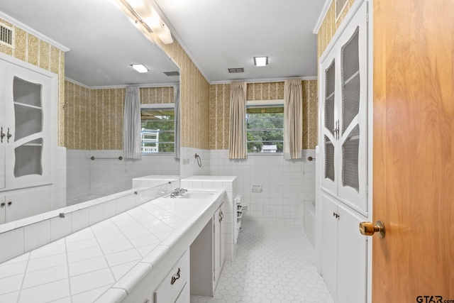 bathroom with a wealth of natural light, tile patterned floors, toilet, and tile walls