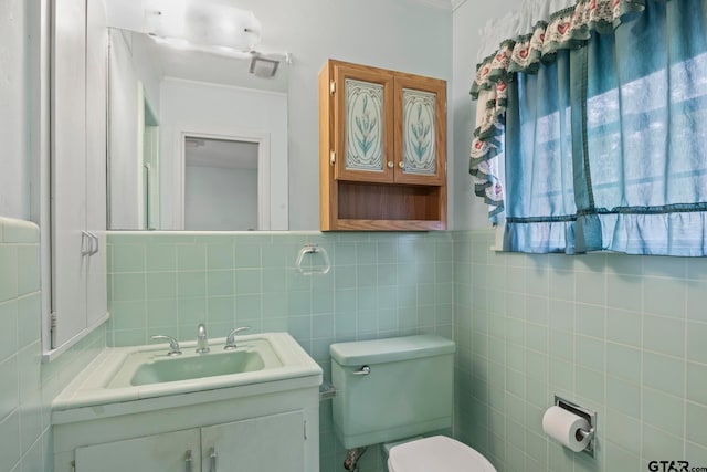 bathroom featuring toilet, vanity, and tile walls