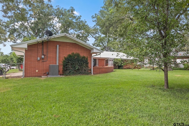 view of side of property featuring cooling unit and a lawn