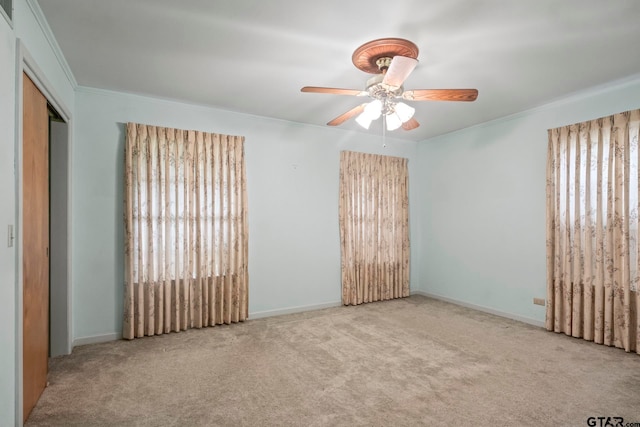 carpeted empty room featuring ceiling fan and ornamental molding