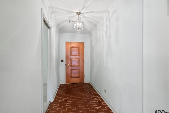 hall with an inviting chandelier and crown molding