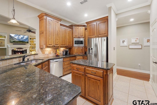 302 Coventry St, Bullard, TX 75757 - kitchen featuring appliances with stainless steel finishes, a ceiling fan, light tile patterned flooring, a lit fireplace, and backsplash