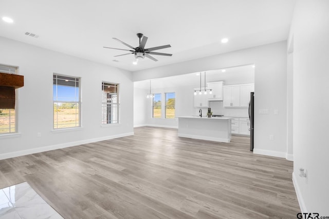 2062 County Road 1612, Alba, TX 75410 - unfurnished living room with ceiling fan, recessed lighting, light wood-style floors, baseboards, and a sink