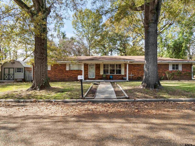 ranch-style home featuring a storage shed