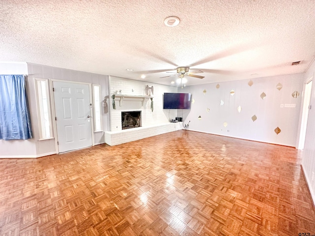 13909 Joe B Fulgham Cir, Brownsboro, TX 75756 - unfurnished living room with baseboards, a ceiling fan, a textured ceiling, and a fireplace