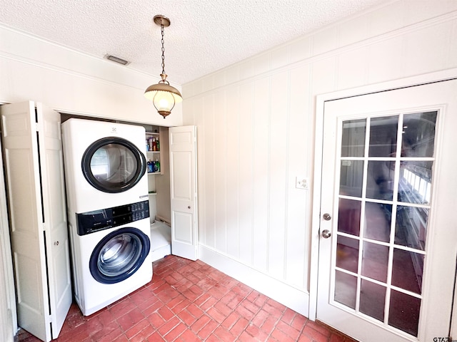13909 Joe B Fulgham Cir, Brownsboro, TX 75756 - clothes washing area with stacked washing machine and dryer, brick floors, a textured ceiling, and baseboards