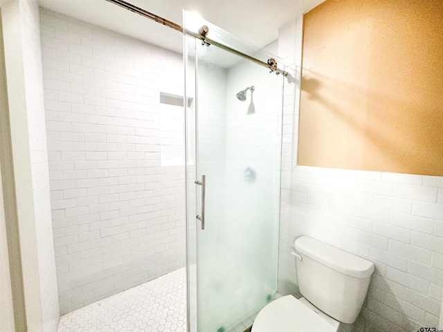 13909 Joe B Fulgham Cir, Brownsboro, TX 75756 - bathroom with toilet, a shower stall, a wainscoted wall, and tile walls