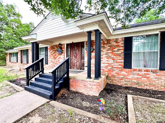 13909 Joe B Fulgham Cir, Brownsboro, TX 75756 - doorway to property featuring brick siding and a porch