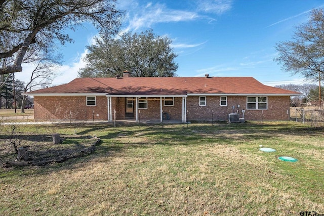 back of house with central AC and a yard