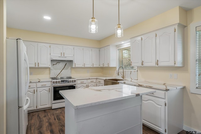 kitchen featuring white fridge, hanging light fixtures, stainless steel electric range oven, light stone countertops, and white cabinets