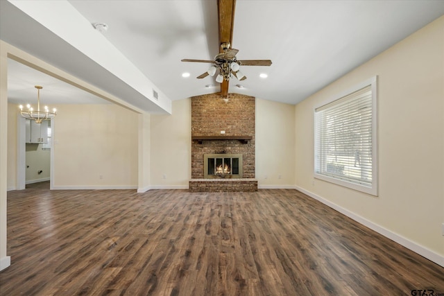 unfurnished living room featuring vaulted ceiling with beams, a brick fireplace, dark hardwood / wood-style flooring, and ceiling fan with notable chandelier