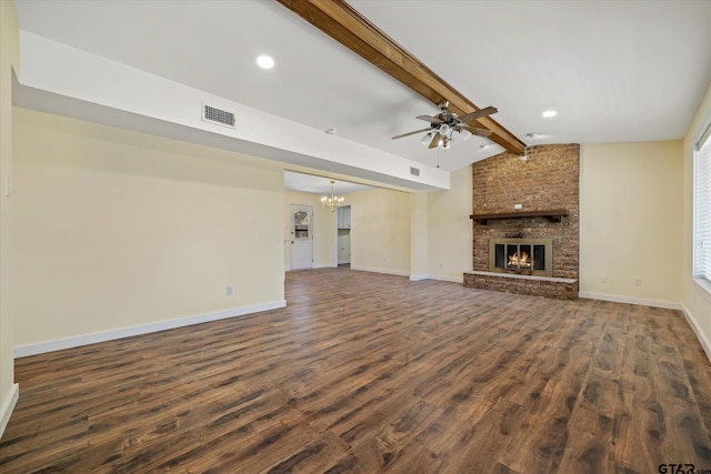 unfurnished living room with a brick fireplace, dark wood-type flooring, lofted ceiling with beams, and ceiling fan with notable chandelier