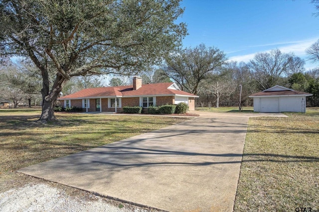 single story home featuring a front yard, an outbuilding, and a garage