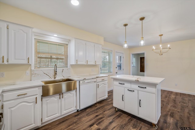 kitchen with decorative light fixtures, white dishwasher, white cabinetry, and sink