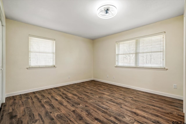 unfurnished room with a wealth of natural light and dark hardwood / wood-style flooring