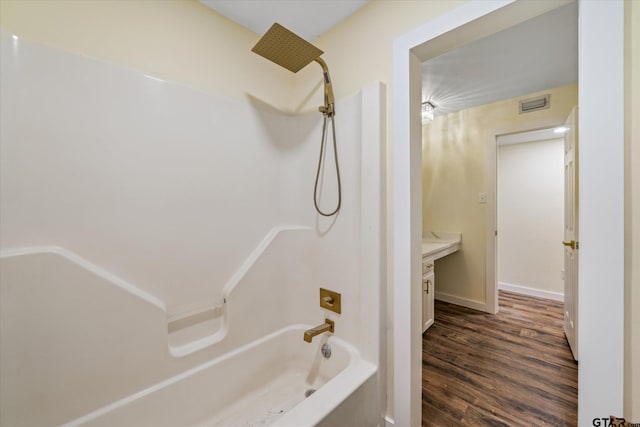 bathroom with vanity, washtub / shower combination, and hardwood / wood-style flooring