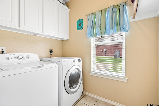 washroom with washer and dryer, light tile patterned floors, and cabinets