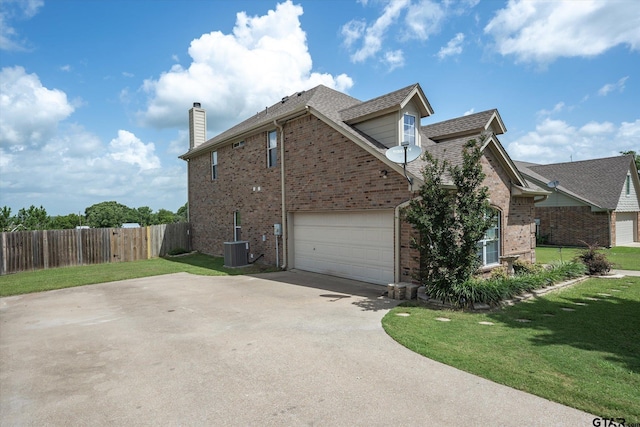 view of side of home with a yard, a garage, and cooling unit