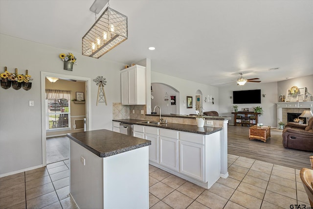 kitchen with white cabinets, decorative light fixtures, a center island, and sink