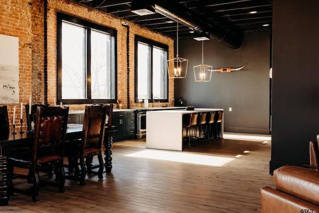 dining area featuring brick wall and hardwood / wood-style floors