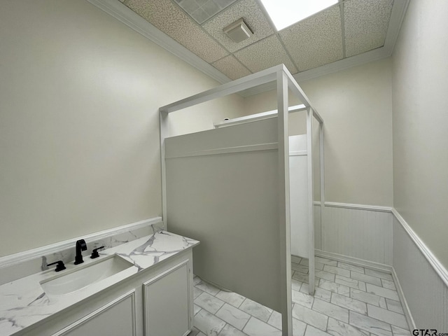 bathroom with a drop ceiling, vanity, and crown molding