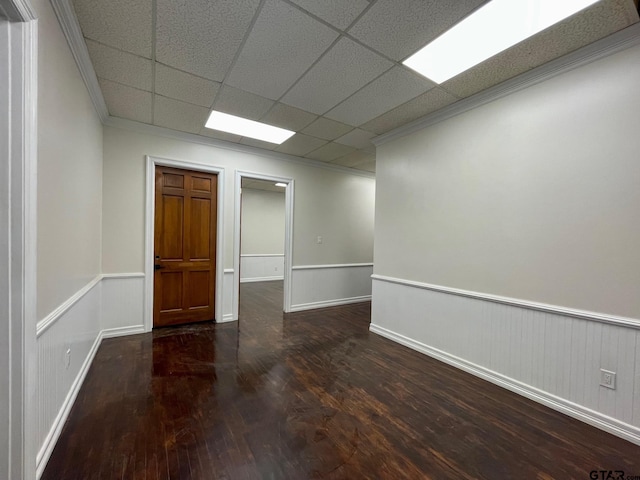 unfurnished room with ornamental molding, a paneled ceiling, and dark hardwood / wood-style flooring