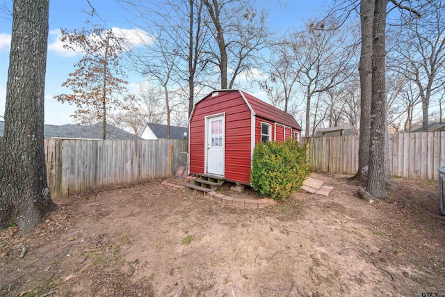 view of outdoor structure featuring entry steps, a fenced backyard, and an outbuilding