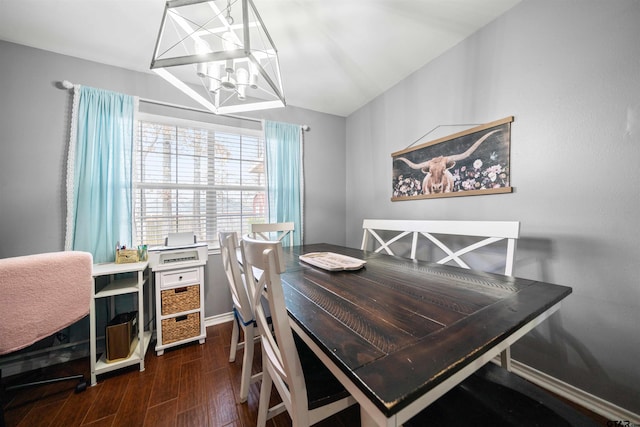 dining area featuring baseboards, dark wood finished floors, lofted ceiling, and a notable chandelier