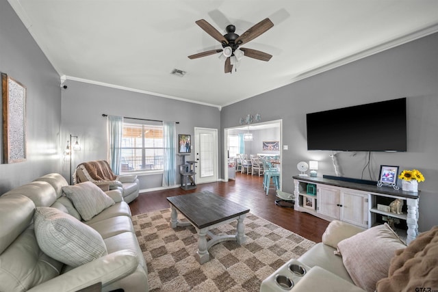 living room with a ceiling fan, wood finished floors, visible vents, and crown molding