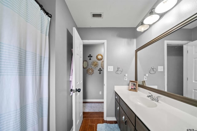 full bath with wood tiled floor, visible vents, baseboards, and vanity