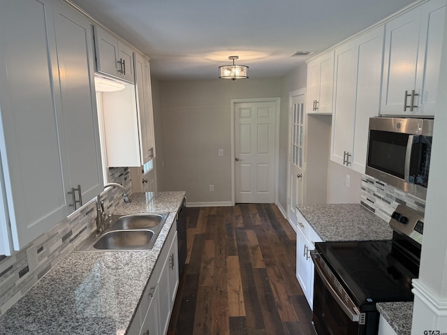 2533 Chelsea Dr, Tyler, TX 75701 - kitchen with stainless steel appliances, backsplash, dark wood-style floors, and white cabinets