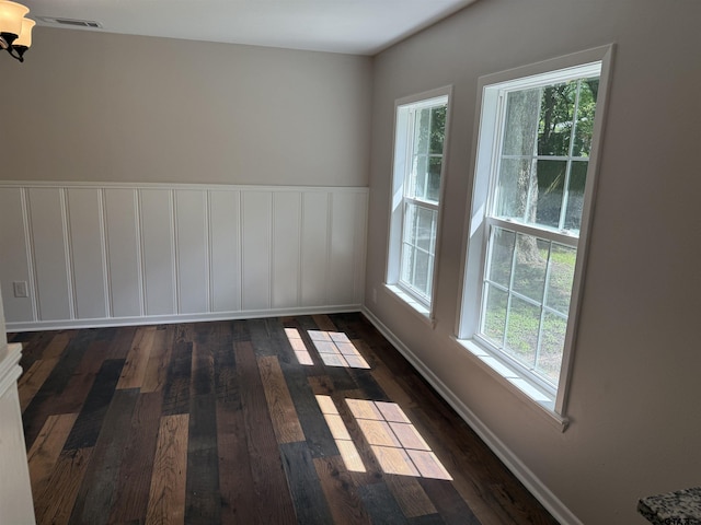 2533 Chelsea Dr, Tyler, TX 75701 - unfurnished room with healthy amount of natural light, dark wood-style floors, wainscoting, and a chandelier