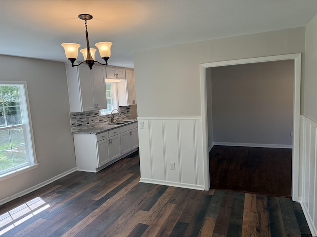 2533 Chelsea Dr, Tyler, TX 75701 - kitchen featuring dark wood finished floors, tasteful backsplash, hanging light fixtures, a chandelier, and light stone counters
